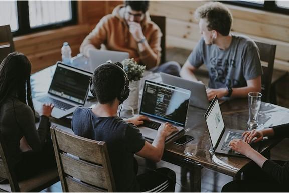 Tecton Logic team collaborating around laptops in a meeting room